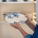 A Woman Putting a Ceramic Plate on a Pile Copy