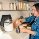 A Woman Putting Chili in a Glass Jar One