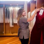 A Woman Putting a Dress on a Rack Space